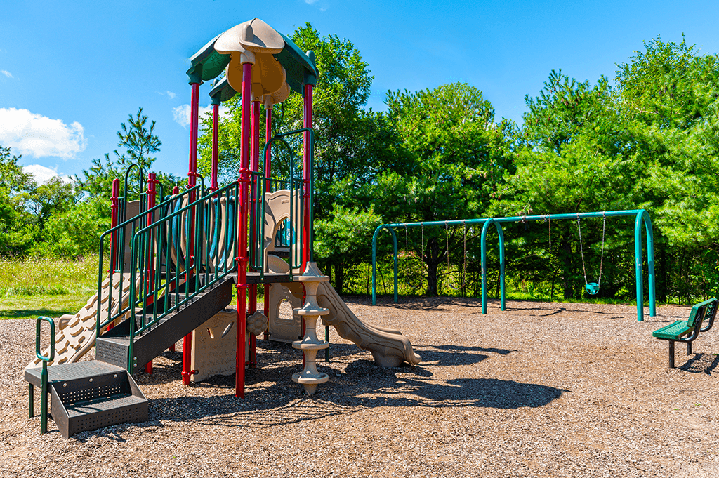 Playground at North Lake Apartments with slides and swings.