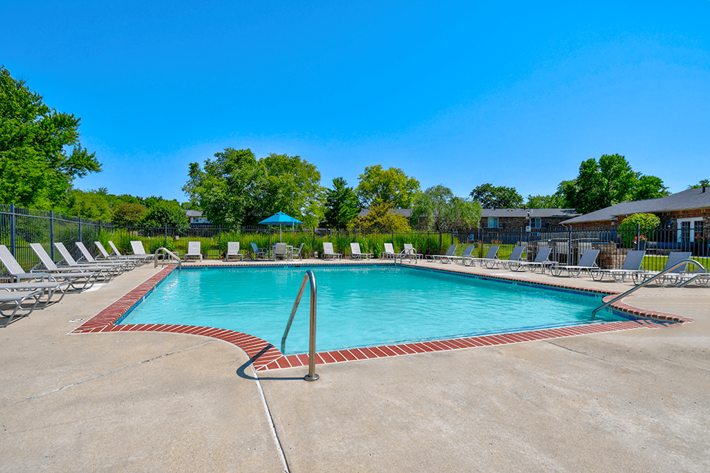 Swimming pool at Ashton Brook Apartments, offering a relaxing outdoor space for residents, with lounge seating nearby.