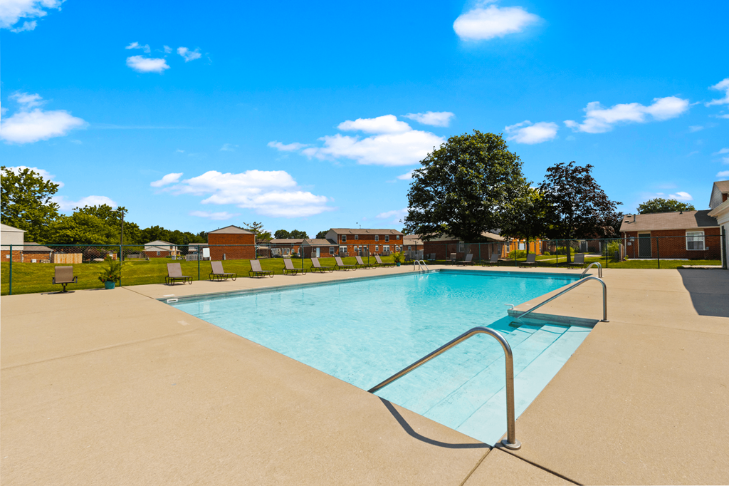 Swimming pool at Windsor Park Apartments, surrounded by lounge chairs offering a relaxing outdoor space.