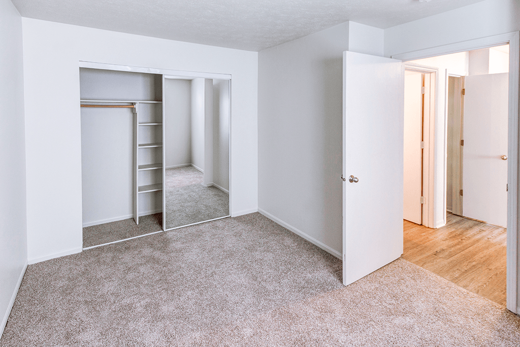Primary bedroom in a 2-bedroom, 1-bath apartment at Woodland Crossing, offering neutral walls and carpeted flooring.