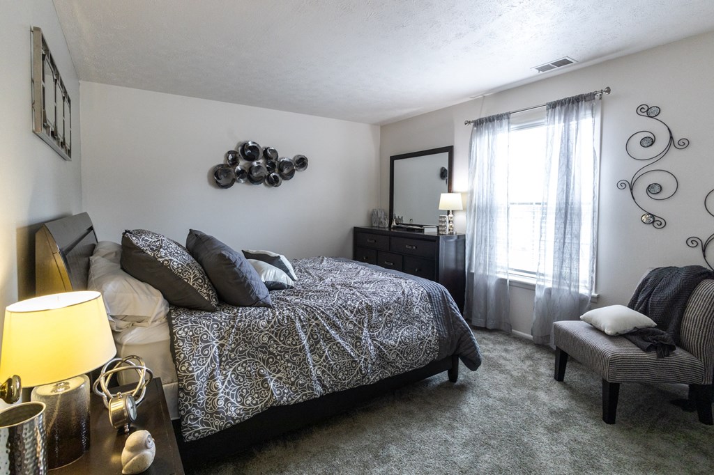 a bedroom with a bed and a dresser and a window