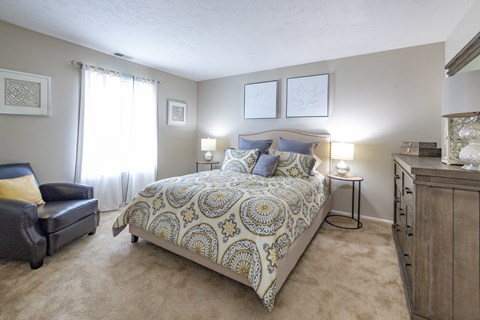 a bedroom with a bed and a dresser and a window