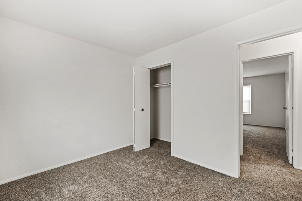 Secondary bedroom in a two-bedroom, one-bath Windsor Park apartment, featuring carpeted floors, and a closet.