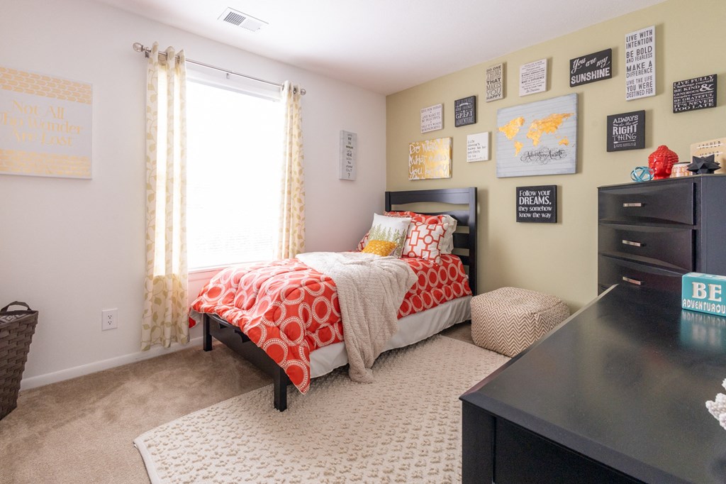 a bedroom with a bed and a dresser and a window