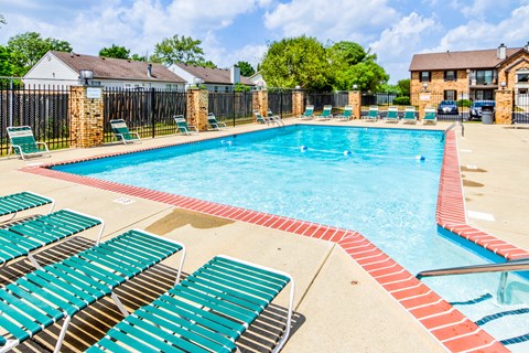 Swimming pool with seating at Cedar Ridge Apartmenrts