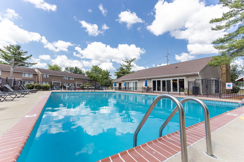 Outdoor swimming pool with seating at Woodbridge Apartments