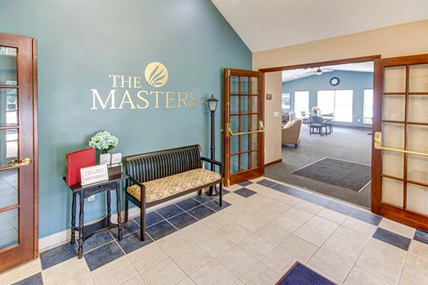 A reception area with a bench and a sign that says "The Masters".