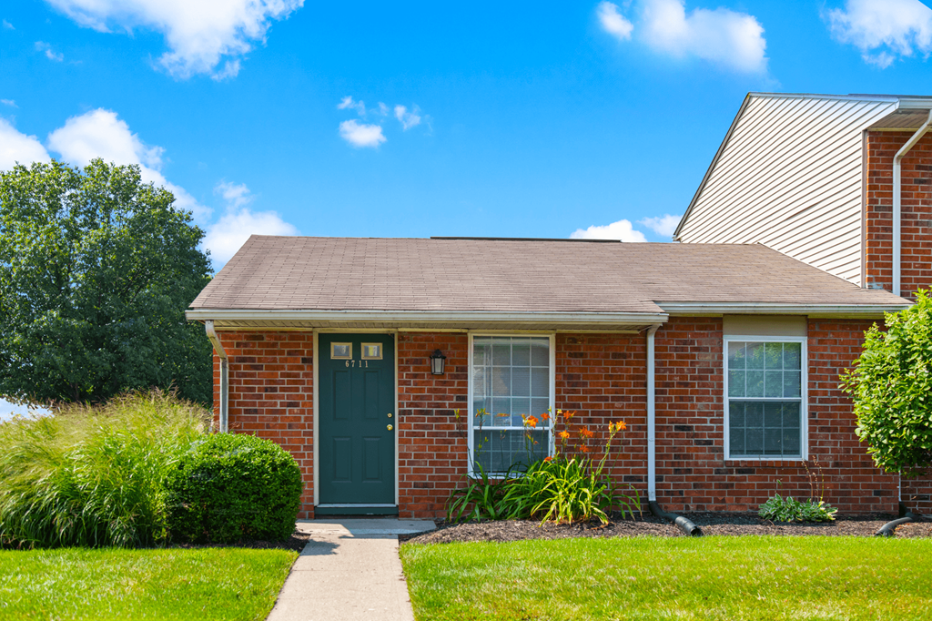 Exterior view of Windsor Park Apartments, with well-maintained landscaping, and inviting entryways.