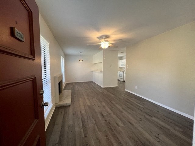 an empty living room with a ceiling fan