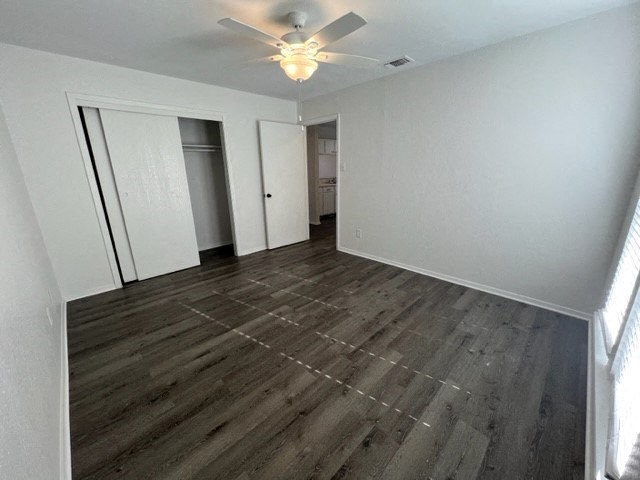 an empty living room with a ceiling fan