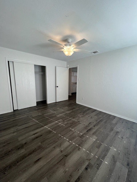 an empty living room with a ceiling fan