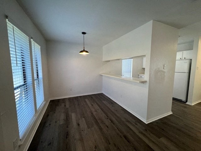 an empty room with a kitchen and a large window