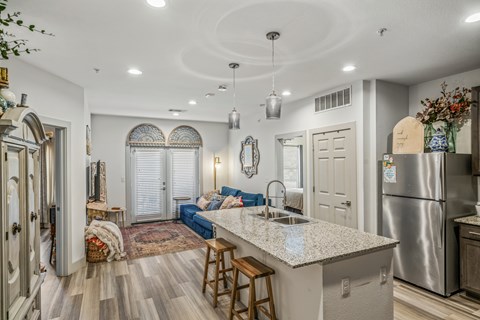 A kitchen with a large island and a refrigerator.