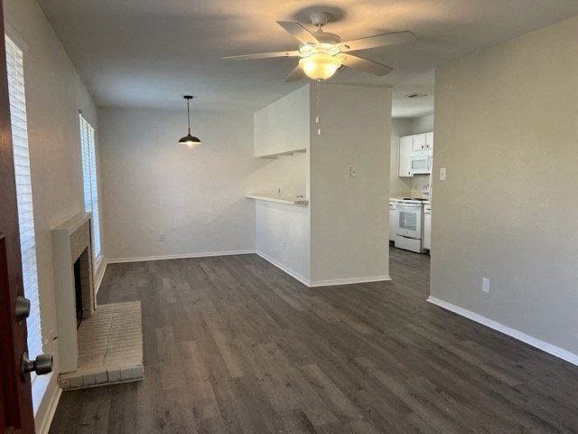 an empty living room and kitchen with a ceiling fan