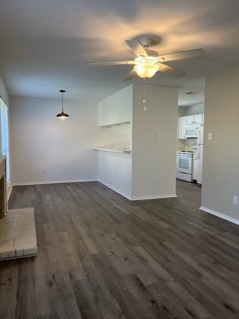 an empty living room with a ceiling fan