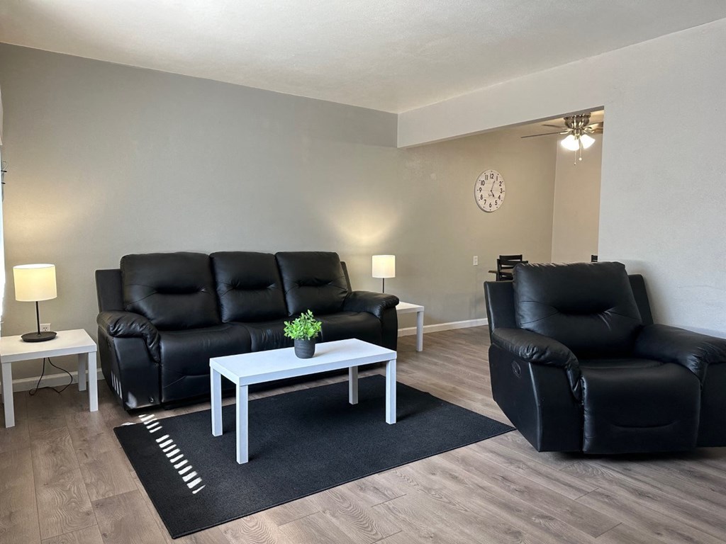 a living room with black leather furniture and a white coffee table