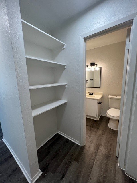 a bathroom with a toilet and shelves in it