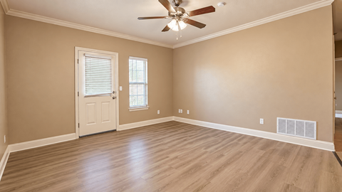 A room with a ceiling fan and a door.