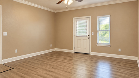 A room with a ceiling fan and a door.