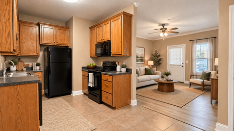 A kitchen with a black refrigerator and wooden cabinets.