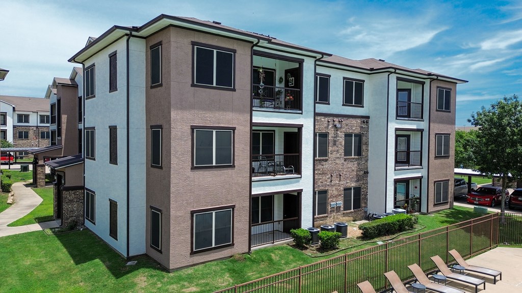 Apartment building with a green lawn in front.