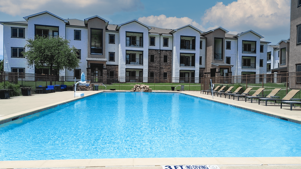 A swimming pool in front of apartment buildings.