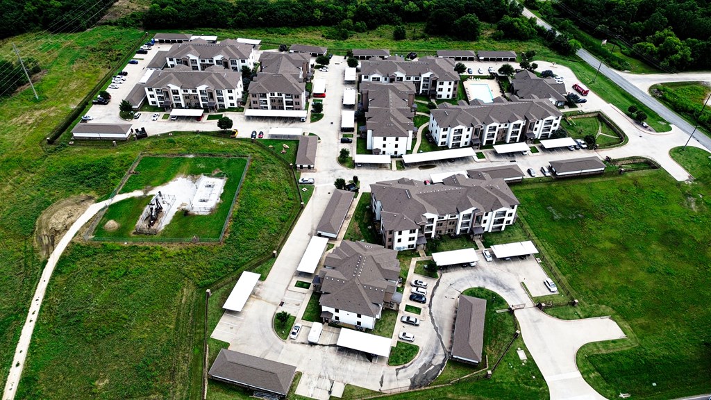 A bird's eye view of a housing development with multiple houses and a central courtyard.