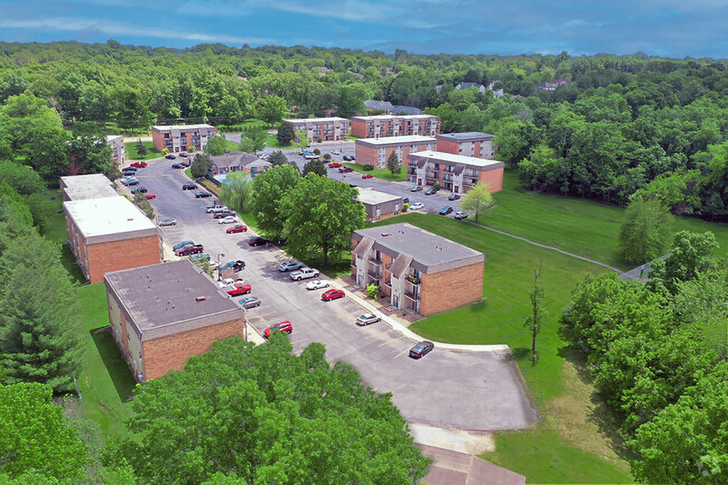 A parking lot with cars and a building in the background.