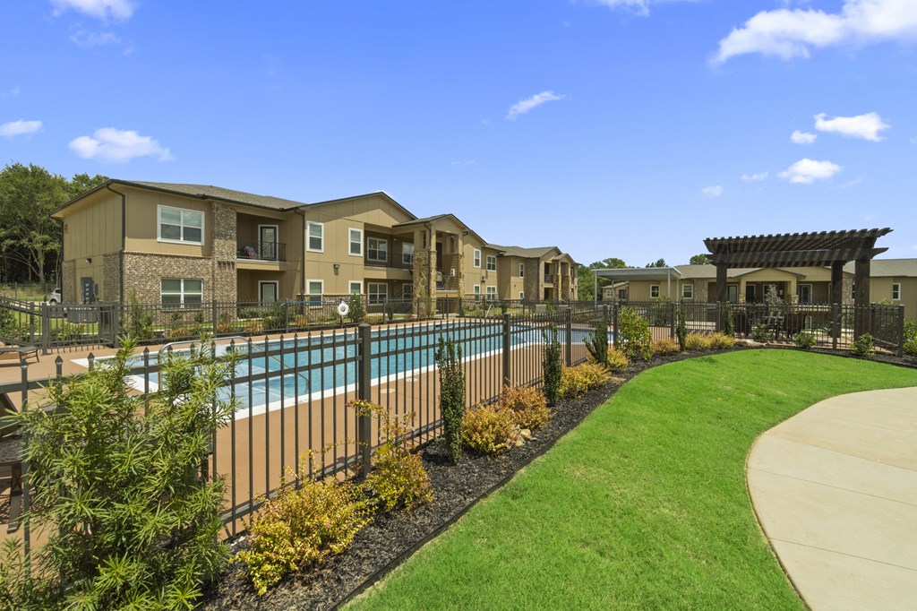 a swimming pool with a fence in front of an apartment building