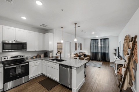 A modern kitchen with white cabinets and stainless steel appliances.