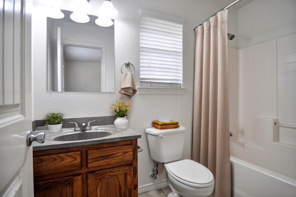 A bathroom with a toilet, sink, and shower.