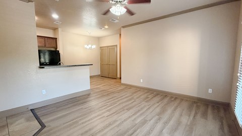 A room with a ceiling fan and a television on a counter.