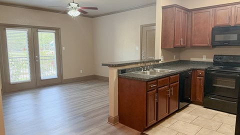 A kitchen with wooden cabinets and black appliances.