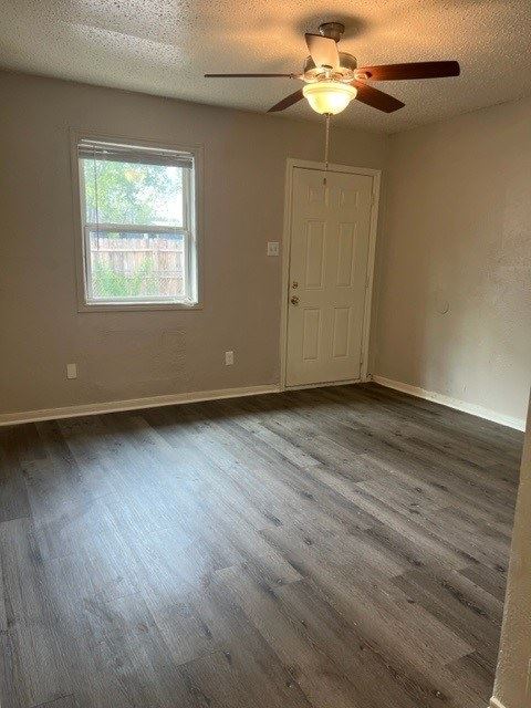 an empty living room with a ceiling fan and a door