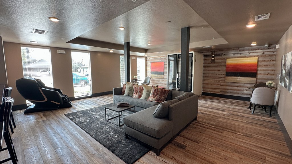 A living room with a grey couch and a black chair.