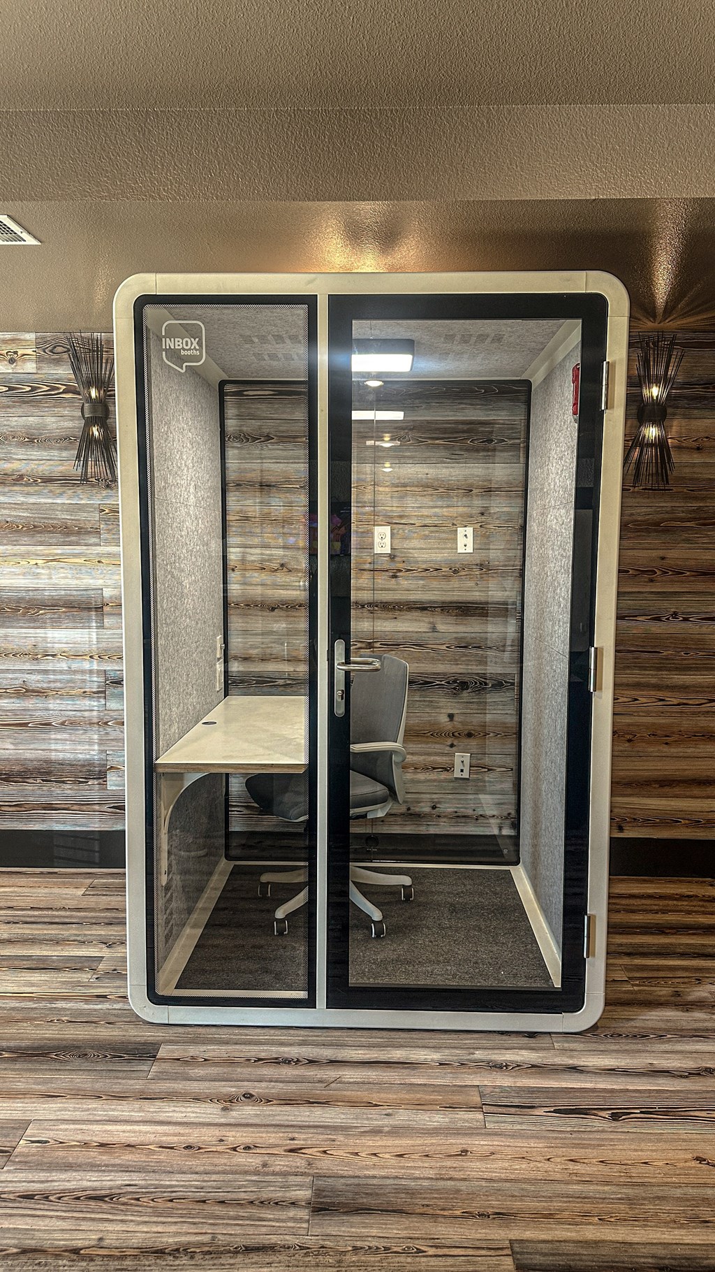 A room with a wooden wall and a glass door.