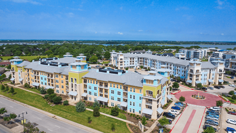 an aerial view of an apartment complex with a lake in the background