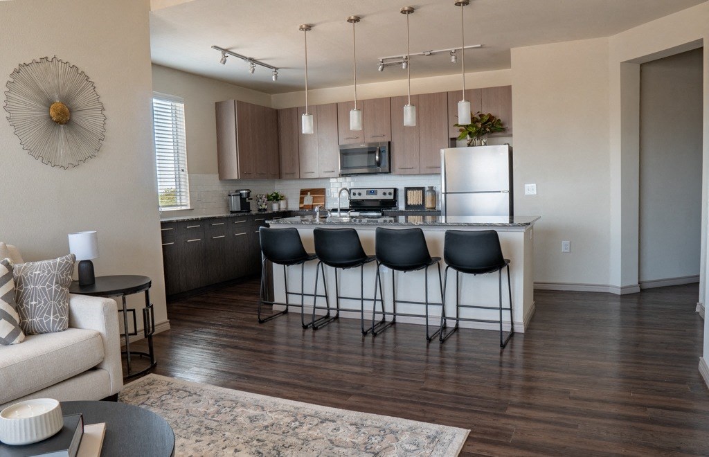 a kitchen with a large center island next to a living room