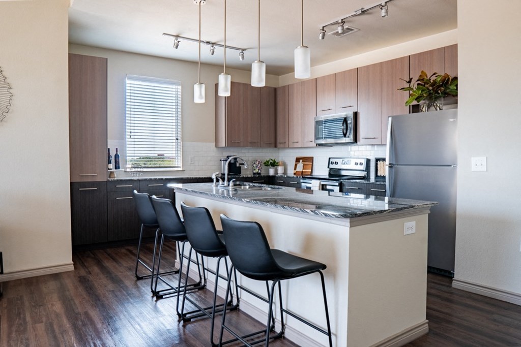 a kitchen with a large center island with a breakfast bar