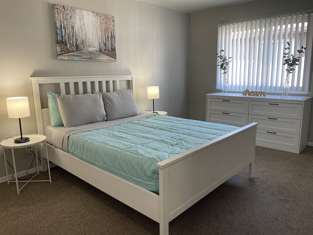 a bedroom with a bed and a dresser and a window at shiloh commons