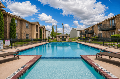 A swimming pool surrounded by apartment buildings on a sunny day.