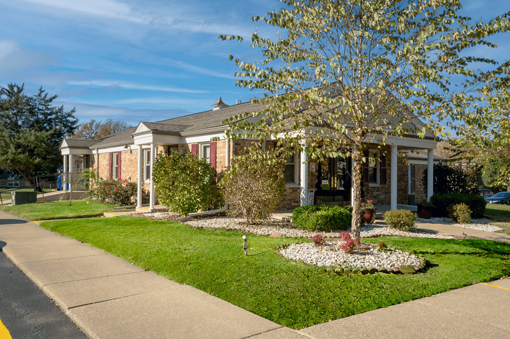 A house with a front yard and a tree.