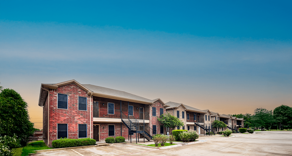 A large red brick building with a parking lot in front.
