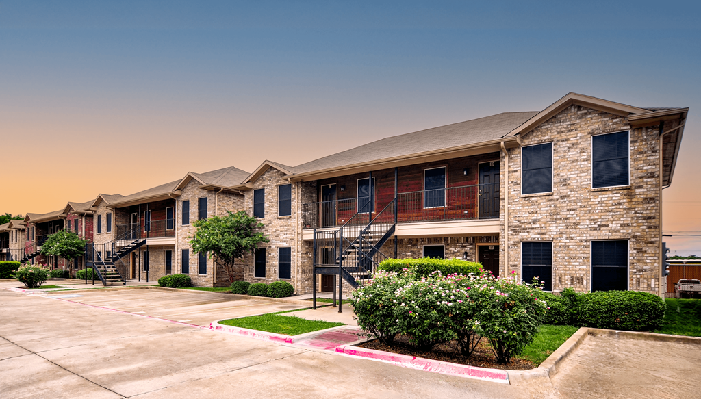 A large, modern building with a stone facade and a red awning.