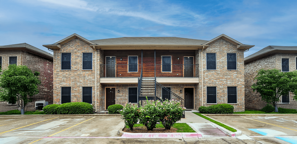 A large brick house with a balcony on the second floor.