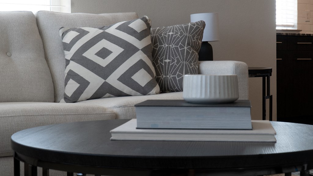 a coffee table with a book and a candle on it
