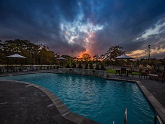 a swimming pool with a sunset in the background