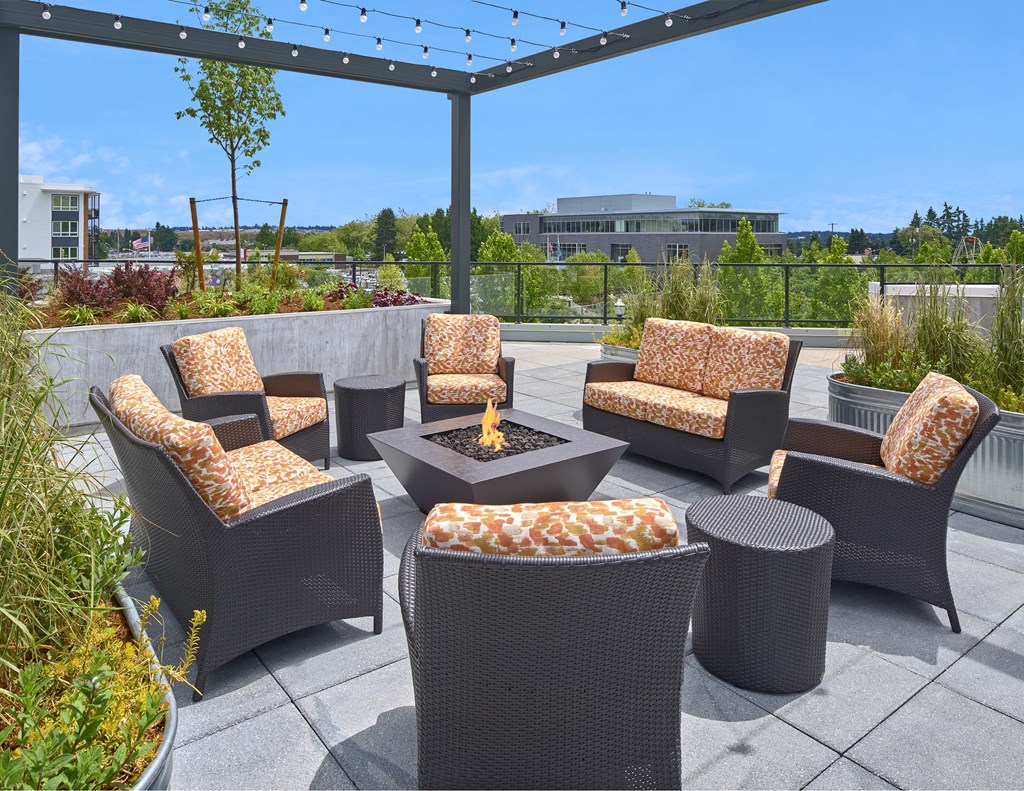 a patio with chairs and a fire pit on a roof