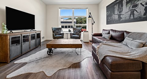 A living room with a brown leather couch and a wooden coffee table.