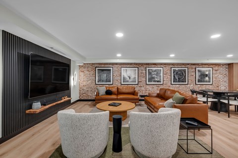 A modern living room with a brick wall and a wooden floor.